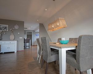 Eetgedeelte van Waddenhuis vakantiehuis in Westerland met stijlvolle verlichting en houten tafel.