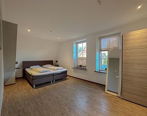 Ruime slaapkamer in Waddenhuis vakantiehuis, Westerland met comfortabele bedden en veel licht.