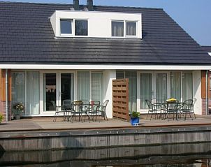 Ruim terras aan het water bij MeerParel vakantiehuis in Uitgeest, Noord-Holland, ideaal om te ontspannen.