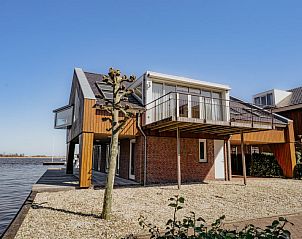 Lichte woonkamer van Appartement Penthouse in Uitgeest, Noord-Holland, met uitzicht op de jachthaven.