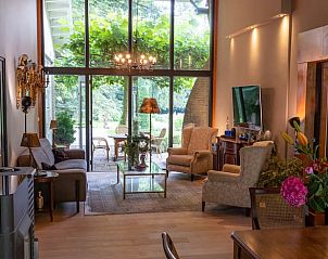 Woonkamer met uitzicht op de tuin in Huisje in Laren, vakantieaccommodatie in Laren, Amsterdam eo, Noord-Holland.