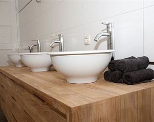 Moderne badkamer in Landgoed Nieuwhuis vakantiehuis in Ootmarsum, Twente met stijlvolle wastafels en houten details.