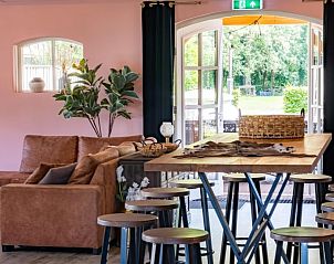 Gezellige zithoek in Landgoed Nieuwhuis vakantiehuis in Ootmarsum, Twente, met uitzicht op de tuin.