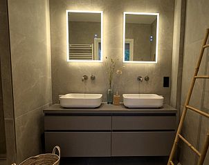 Moderne badkamer in Vakantiehuis in Oldenzaal, Twente, met dubbele wastafel en sfeerverlichting.