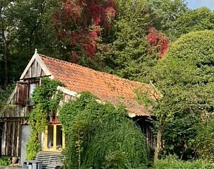 Rustieke vakantiewoning in Boekelo, Enschede met rode dakpannen, ideaal gelegen tussen weelderige bomen in het hart van Twente.