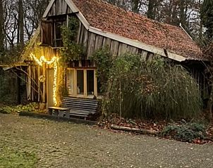 Vakantiehuisje in Boekelo, Enschede verlicht met sfeervolle lichtjes, biedt een warme en uitnodigende sfeer in de Twentse natuur.