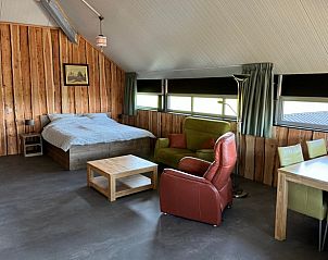 Gezellige binnenruimte van Vakantiehuisje in Boskamp, Salland, met comfortabele zithoek en rustieke inrichting.