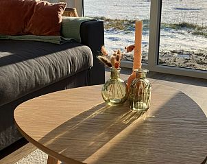 Gezellige woonkamer in Huisje in Bruchterveld met uitzicht op besneeuwd landschap.