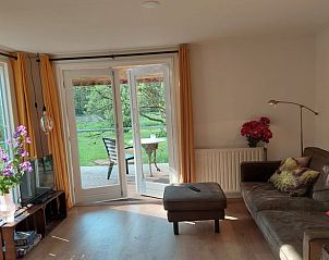 Woonkamer van Vakantiehuis in Dedemsvaart, vakantiehuis in Vechtstreek, Overijssel met toegang tot terras.