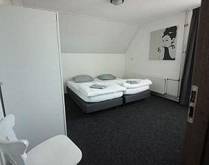 Sfeervolle slaapkamer in Vakantiehuis Giethoorn, Overijssel, met tweepersoonsbedden voor een ontspannen verblijf.