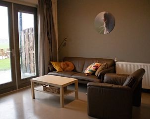 Lichte woonkamer in Huisje in Steenwijk, vakantieaccommodatie in Overijssel, met uitzicht op tuin en stijlvolle inrichting.