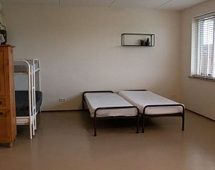 Ruime slaapkamer in Huisje in Steenwijk, Overijssel, met stapelbed en twee eenpersoonsbedden voor een ontspannen verblijf.