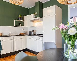 Eethoek in Vakantiehuis in Wetering, Overijssel met design stoelen en houten vloer.