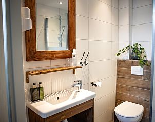 Sfeervolle details in OV683 vakantiehuis, Blokzijl, met bloemen en klok op een tafel in Noordwest Overijssel.