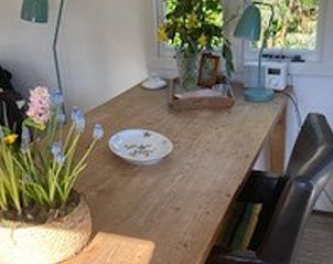 Ruime eettafel in Vakantiehuisje in Basse, Noordwest Overijssel, met bloemen en decoraties.