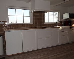 Moderne keuken in strandhuis De Bakkeete, een bungalow in Kamperland, Noord-Beveland, Zeeland, met ruime werkbladen en natuurlijke lichtinval.