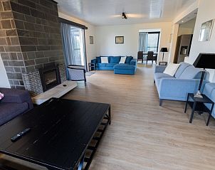 Moderne woonkamer van Mer du Nord, een strandhuis in Breskens, Zeeuws-Vlaanderen, met een open haard en comfortabele banken in Zeeland.