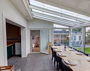 Lichte eetruimte van Heemsdael vakantiehuis in Breskens, Zeeuws-Vlaanderen met uitzicht op de tuin.