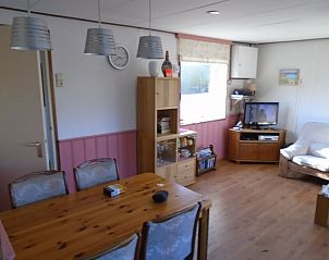 Woonkamer in Het Zomernest, Ouddorp, met houten vloer en sfeervolle inrichting voor een huiselijke sfeer.