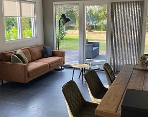 Lichte woonkamer met houten balken in vakantiehuis Vrijheid, Ouddorp, Goeree-Overflakkee, Zuid-Holland.