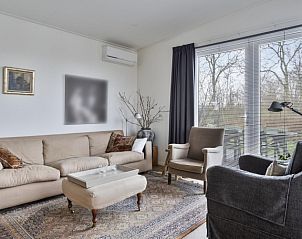 Comfortabele woonkamer in Cabin, Grote Stern 16, Ouddorp met ruime zithoek en uitzicht op de natuur van Goeree-Overflakkee.