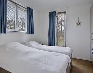 Slaapkamer in Cabin, Grote Stern 16, Ouddorp met twee bedden en uitzicht op de omgeving van Goeree-Overflakkee, Zuid-Holland.