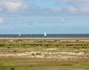 Uitzicht op zee nabij Tiny House Jet in Goedereede, met zeilboten aan de horizon.