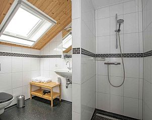 Sfeervolle slaapkamer in vakantiehuis ZH017, Gouda, met houten details en bloemendecor.