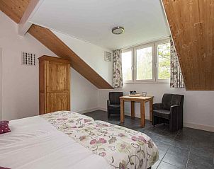 Moderne woonkamer met houten trap in vakantiehuis ZH017, Gouda, Zuid-Holland.