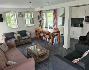 Comfortabele zithoek in ZH017 vakantiehuis, Gouda, met kleurrijke gordijnen.