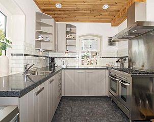 Ruime woonkamer in ZH018 vakantiehuis Gouda, met kleurrijke gordijnen en veel natuurlijk licht.