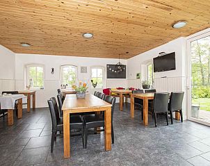 Slaapkamer in ZH018 vakantiehuis Gouda, met paarse muur en comfortabele bedden.