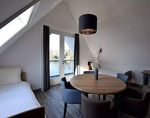 Zitkamer met uitzicht op het water in Villa Kaagervaaring, vakantiehuis in Kaag, Zuid-Holland.