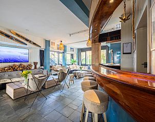 Gezellige binnenruimte van De Kaag Watersport Groepsaccommodatie in Kaag, Zuid-Holland, met een sfeervolle bar en comfortabele zithoek.