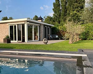 Moderne buitenkant van Vakantiehuis in Ammerstol met terras en groene tuin in Zuid-Holland.