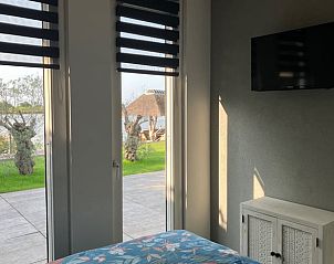 Uitzicht vanuit de slaapkamer op de tuin en rivier bij Vakantiehuis in Ammerstol.