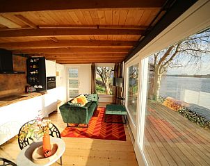 Lichte woonkamer met uitzicht in Vakantiehuis in Lekkerkerk, Groene Hart, Zuid-Holland.