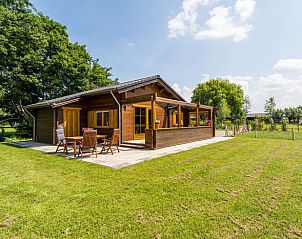 Zonnig terras bij Vakantiehuisje in Ameide met houten stoelen en een prachtig uitzicht op de natuur.
