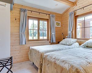 Sfeervolle slaapkamer met twee eenpersoonsbedden in Vakantiehuisje in Ameide, omringd door groen.