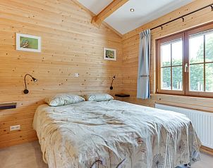 Ruime slaapkamer in Vakantiehuisje in Ameide met veel natuurlijk licht en houten afwerking.