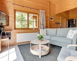 Lichte woonkamer in Vakantiehuisje in Ameide met comfortabele bank en uitzicht op de tuin.