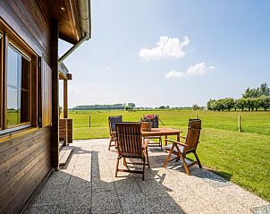 Zonnig terras met houten tafel en stoelen bij Vakantiehuisje in Ameide, ideaal voor buiten dineren.