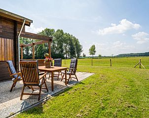 Terras met uitzicht op groene velden bij Vakantiehuisje in Ameide, Zuid-Holland.