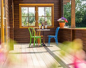 Kleurrijke stoelen op de veranda van Vakantiehuisje in Ameide, perfect voor een ontspannen middag.