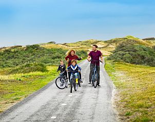 Gezin fietst door de duinen bij Tulp & Zee, Noordwijkerhout, aan de Noordzeekust.