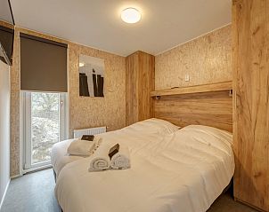 Sfeervolle slaapkamer in Comfort 6A chalet, Kijkduin, Noordzeekust, met knusse inrichting en natuurlijk licht.