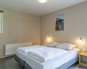 Ruime slaapkamer in Comfort 2 Mindervalide chalet, Kijkduin, met tweepersoonsbed en rustgevende sfeer.