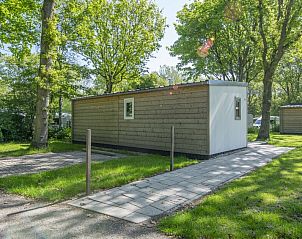 Zijaanzicht van Comfort 2 Mindervalide chalet, Kijkduin, met groene omgeving en wandelpad.