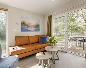Gezellige woonkamer van Comfort 4 Wellness in Kijkduin, Zuid-Holland met comfortabele bank en uitzicht op natuur.