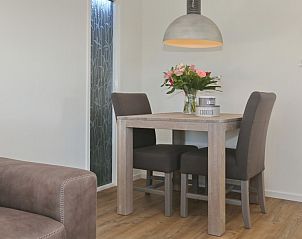 Eethoek met bloemen in De Duinpan 21 chalet, Noordwijk aan zee, Noordzeekust, Zuid-Holland, ideaal voor gezellige maaltijden.